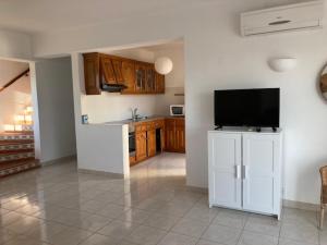 a living room with a kitchen with a flat screen tv at Family Tailor Made Flat in VSR in Porches