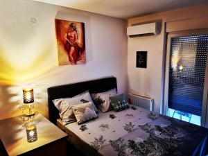 1 dormitorio con 1 cama y una foto en la pared en Apartment CITY en Doboj