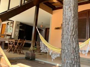 a porch with a hammock and a tree in a house at Pousada Hibiscos in Serra do Cipo