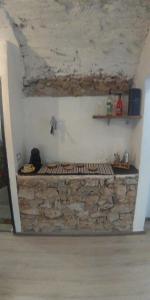 Cette chambre est dotée d'un mur en pierre avec une étagère. dans l'établissement Apartment Coffee Time, à Cisano sul Neva