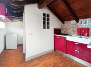 uma cozinha com armários vermelhos e um lavatório em La vita è bella - Noli em Noli