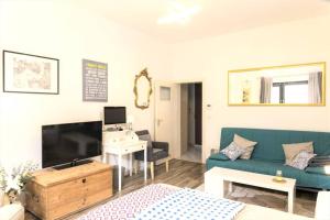 un soggiorno con divano blu e TV di Beautiful Cozy 1-Room apartment, near Rhine a Dusseldorf