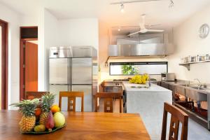 una cocina con una mesa con un bol de fruta. en Nisala Villas, en Mirissa