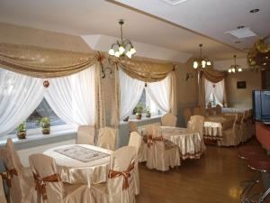 a banquet room with tables and chairs and windows at Hotel Villa Nova in Żagań