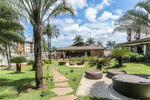 a park with a palm tree and a building at Flat no Life Resort a Beira Lago in Brasília