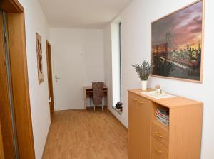 a hallway with a dresser and a painting on the wall at Apartma Čuk in Dutovlje