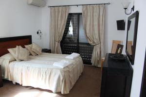 a bedroom with a bed and a table and a window at Alto Club Apartments in Alvor