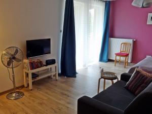 uma sala de estar com um sofá e uma televisão de ecrã plano em Apartament Parkowy em Nałęczów