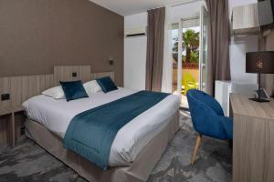 a bedroom with a bed and a desk and a chair at Relax'Otel & Spa, Le Barcarès - Port Leucate in Le Barcarès