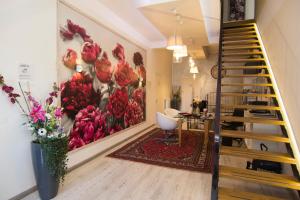 a living room with a staircase and a painting of flowers at B&B 7 Rooms in Pisa
