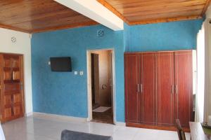 Masai Game Resort في نيروبي: غرفة معيشة مع جدران زرقاء وسقوف خشبية