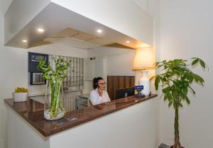 a man sitting at a desk talking on a cell phone at Hotel Stella D'Italia in Viareggio