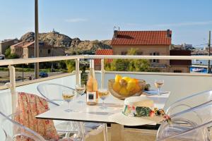 una mesa con copas de vino y un bol de fruta en Residence Des Îles, en LʼÎle-Rousse