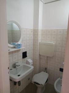 uma casa de banho com um lavatório, um WC e um espelho. em Hotel Graziella Mare em Rimini
