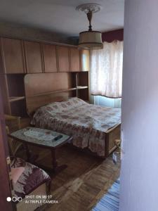 ein Schlafzimmer mit einem Bett und einem Tisch darin in der Unterkunft apartmani mejdan in Tuzla