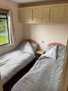 two beds in a small room with a window at Tummel 2 in Forfar