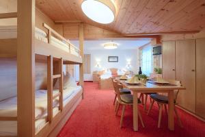 a room with bunk beds and a table and chairs at Pension Hochkönigblick in Sankt Johann im Pongau