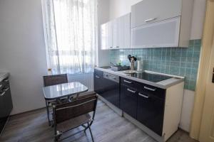 eine Küche mit einer Spüle sowie einem Tisch und Stühlen in der Unterkunft Apartman Gaudeamus in Varaždin