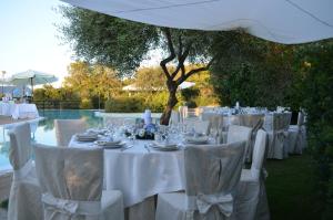 a table set up for a wedding with white tables and chairs at Hotel Giardino Corte Rubja in Iglesias