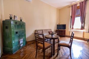 a living room with a table and chairs and a television at Apartman Gaudeamus in Varaždin