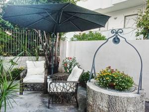 a patio with a table and an umbrella and chairs at B&B Villa dei Desideri in Praia a Mare