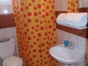 a bathroom with a sink and a toilet and a shower curtain at Villa Gesthimani in Neos Marmaras