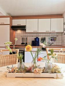 una mesa con jarrones de flores en una cocina en flex living - Business- und Ferienwohnung Wassermann, en Dresden