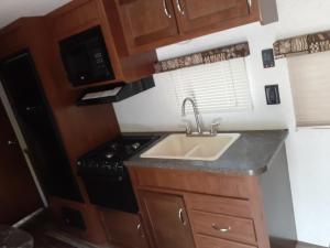 a small kitchen with a sink and a stove at 2017 Camper located at the St. George RV Park! in St. George