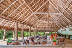 a large pavilion with tables and chairs and an airplane at The Explorean Kohunlich - All Inclusive in Ruinas Kohunlích