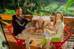 a man and a woman sitting at a table at Chalé Suiço Bombinhas in Bombinhas