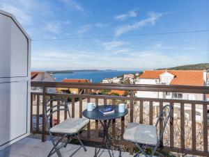 balcón con mesa, sillas y vistas al agua en Apartments and Rooms Ivanović en Hvar