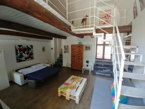 a living room with a bed and a spiral staircase at Asso Di Coppa in Scafati