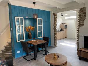 霍勒姆的住宿－Kakebiën，一间设有桌子和蓝色墙壁的用餐室