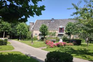 una casa con jardín y flores delante de ella en B&B Landgoed Rijckholt, en Geersdijk