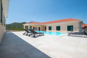 a villa with a swimming pool and two lounge chairs at LUXUS-VILLA mit 4 Schlafzimmern und POOL in der Nähe von Dubrovnik Kroatien und Bosnien in Ravno