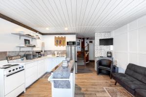 a kitchen and living room with white cabinets and a couch at Pend Orielle Perch in Athol