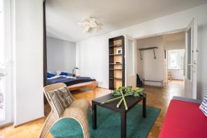 a living room with a bed and a table at oompH Warsaw Central 3-bedroom Flat in Warsaw