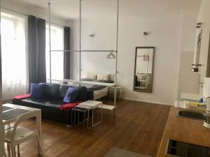 - un salon avec un canapé noir et un miroir dans l'établissement Nice studio in Friedrichschain area, à Berlin
