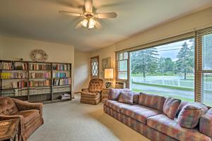 a living room with a couch and a large window at Lake Huron House with Grill and Beach Access! in East Tawas