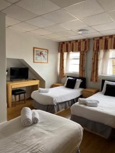 a hotel room with three beds and a desk at Whites Hotel in Newcastle upon Tyne