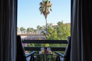 a view of a palm tree from a hotel room at Apartamentos IMPLUVIUM Mérida in Merida