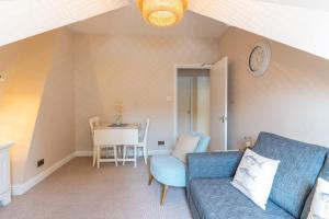 a living room with a blue couch and a table at Stowaways Loft in Whitby