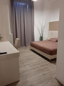 1 dormitorio con cama y escritorio en B&B LEI, en Foggia