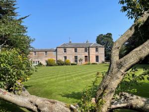 a large house with a large lawn in front of it at Marshall Meadows Manor House in Berwick-Upon-Tweed