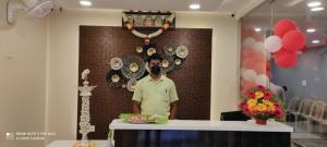 un hombre parado en un mostrador en una habitación en Veeras Residency, en Pondicherry
