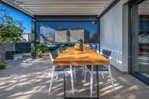 a wooden table and chairs on a patio at Apartma Skubic Duhljica in Vantačići