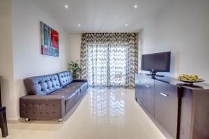 sala de estar con sofá y TV en Apartamentos 7 Saias Marginal en Nazaré