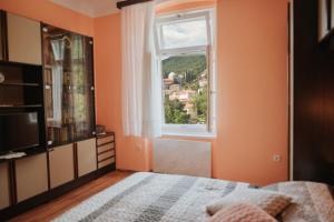 een slaapkamer met een bed en een raam bij Room Malnig Opatija in Opatija