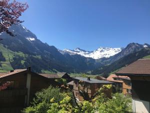 a view of snow capped mountains from a village at Apartment Haldematt by Interhome in Adelboden