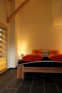 Habitación con 2 camas con almohadas de color naranja en Apartment Burn- Alte Strasse by Interhome, en Adelboden